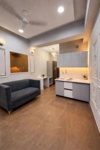 a living room with a couch and a kitchen at Xenious Smart Suites Greater Noida in Noida