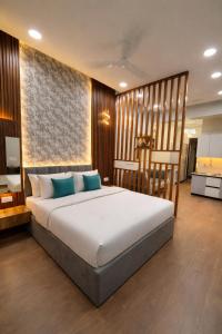 a bedroom with a large bed with blue pillows at Xenious Smart Suites Greater Noida in Noida +48 photos