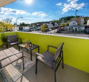 a balcony with chairs and a table and a green wall at Eifeltraum in Daun