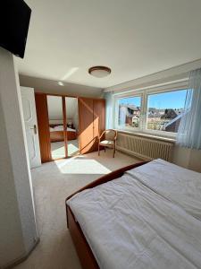 a bedroom with a bed and a chair and a window at Südblick 1 in Fehmarn