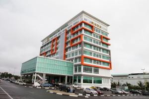 wysoki budynek z samochodami zaparkowanymi na parkingu w obiekcie Promenade Hotel Bintulu w mieście Bintulu