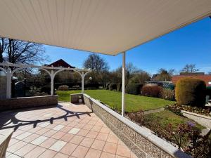 a covered patio with a white pergola at Südblick 1 in Fehmarn