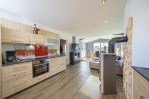 a large kitchen with wooden cabinets and appliances at Ferienpark Achtern Diek Ferienhaus Malmö in Otterndorf +11 photos