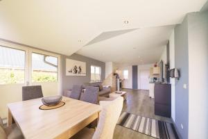 a dining room and living room with a table and chairs at Ferienpark Achtern Diek Ferienhaus Malmö in Otterndorf
