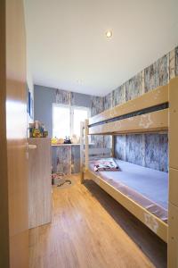 a bedroom with two bunk beds and a wooden floor at Ferienpark Achtern Diek Ferienhaus Malmö in Otterndorf