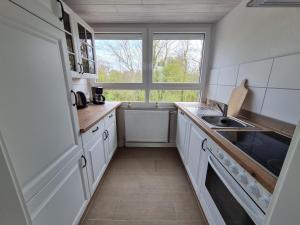a small kitchen with a sink and a window at Ferienwohnung Inselblick Vitzdorf in Fehmarn