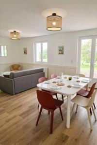 a living room with a white table and chairs at Cadre d'exception et nature - 2 Maisons - 15 pers max in Aigné +8 photos