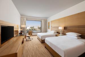 a hotel room with two beds and a flat screen tv at Courtyard by Marriott Gurugram Downtown in Gurgaon