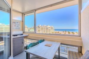 a dining room with a table and views of the ocean at Studio vue mer in Canet-en-Roussillon