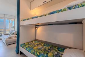 a bedroom with two bunk beds and a couch at Studio vue mer in Canet-en-Roussillon +15 photos