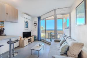 a living room with a couch and a view of the ocean at Studio vue mer in Canet-en-Roussillon