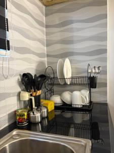 a dish rack with plates and utensils next to a sink at Two bedrooms apartment in Moshi town in Moshi +43 photos