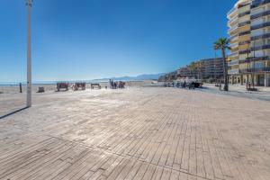 a large boardwalk with a beach and a building at Studio vue mer in Canet-en-Roussillon