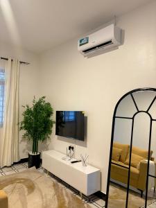 a white living room with a tv and a mirror at Two bedrooms apartment in Moshi town in Moshi