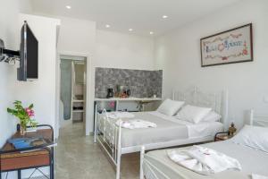 a bedroom with two beds and a table with a desk at Politimis Studio N3 in Amorgos
