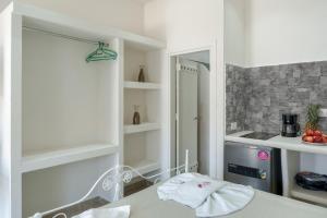 a white room with a bed and a mirror at Politimis Studio N3 in Amorgos +21 photos