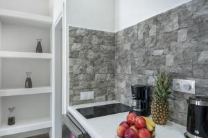 a kitchen with a counter with fruit on a stove at Politimis Studio N3 in Amorgos