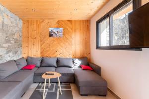 a living room with a couch and a tv at Chalet Les Lys - Tout Confort in Valloire