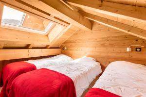 two beds in a log cabin with a window at Chalet Les Lys - Tout Confort in Valloire