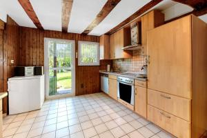 a kitchen with wooden cabinets and a white refrigerator at Ferienhäuschen Kleine Auszeit in Seesbach