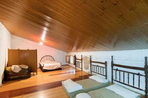 a room with two beds and a wooden ceiling at Casa refugi les Orenetes in Rocafort