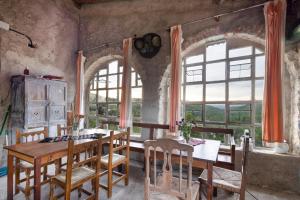 a dining room with a table and some windows at Casa refugi les Orenetes in Rocafort