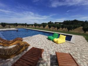 a swimming pool with two wooden chairs and a yellow slide at Domus Nirale in Bagnoregio