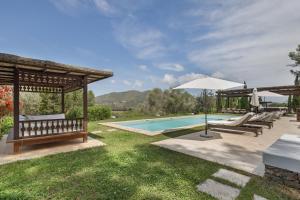 a swimming pool with chairs and an umbrella next to at Can Ribes Ibiza in Illes Balears
