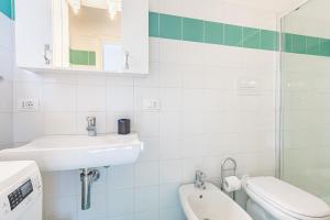 a white bathroom with a sink and a toilet at Trilocale a 200 mt dal centro in San Teodoro +17 photos