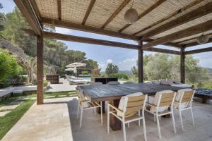 an outdoor dining room with a wooden table and chairs at Can Ribes Ibiza in Illes Balears