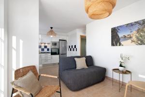 a living room with a blue couch and a kitchen at Tavira Mar in Cabanas de Tavira +13 photos