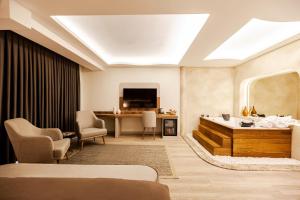 a hotel room with a tub and a television at Avwan Hotels Collection in İzmir
