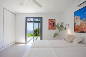 a white bedroom with a large bed and a window at Villa Mar y Muntana in Banyalbufar +37 photos
