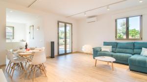 a living room with a blue couch and a table at Can Colomer Ferragut in Artá