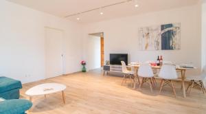 a living room with a table and white chairs at Can Colomer Ferragut in Artá