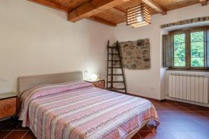 a bedroom with a bed and a wooden ceiling at Casale di Polly in Garfagnana in Minucciano