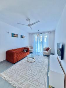 a living room with a red couch and a table at Auryhomes in Mombasa