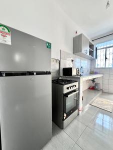 a kitchen with a stainless steel refrigerator and a stove at Auryhomes in Mombasa
