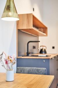 a kitchen with a table with a vase of flowers at Alte Seifensiederei - Cisco in Bad Tölz +11 photos