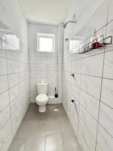 a white bathroom with a toilet and a window at Auryhomes in Mombasa +22 photos