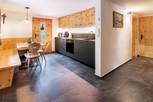 a kitchen with wooden cabinets and a table and chairs at Innerforchhof Schnals in Madonna