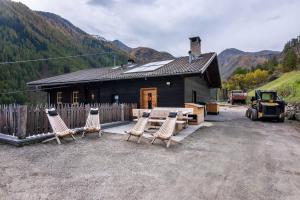 a group of chairs sitting in front of a cabin at Innerforchhof Schnals in Madonna