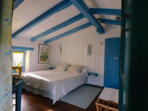 a bedroom with a bed in a room with blue beams at Domaine Xixtaberri in Cambo-les-Bains