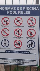 a sign on a fence that warns of possums and other prohibited signs at Casa Chalet, Villa Elisa in Gijón