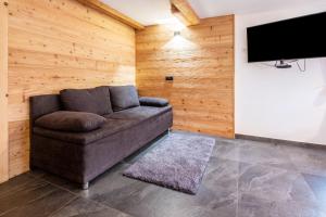 a living room with a couch and a flat screen tv at Innerforchhof Schnals in Madonna