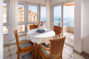 a table and chairs in a room with windows at Bloque 76 in Torrox