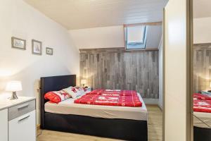 a bedroom with a bed with red pillows at Ferienwohnung Desmecke in Olsberg
