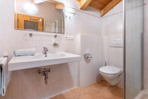 a bathroom with a sink and a toilet at Mansardenwohnung Egart in Resia +19 photos