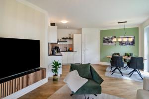 a living room with a flat screen tv and a couch at Fewo Luisa in Bad Zwischenahn +19 photos