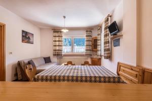 a bedroom with a bed and a tv in it at Casa Lorenz 1 in Canazei